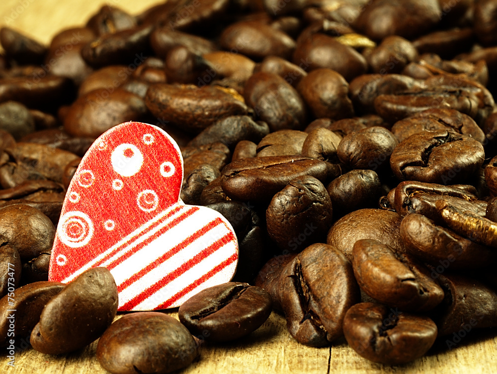 Fototapeta Heart and Coffee beans close-up on wooden table.