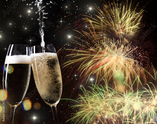 New Year's - toasting with champagne glasses against fireworks a