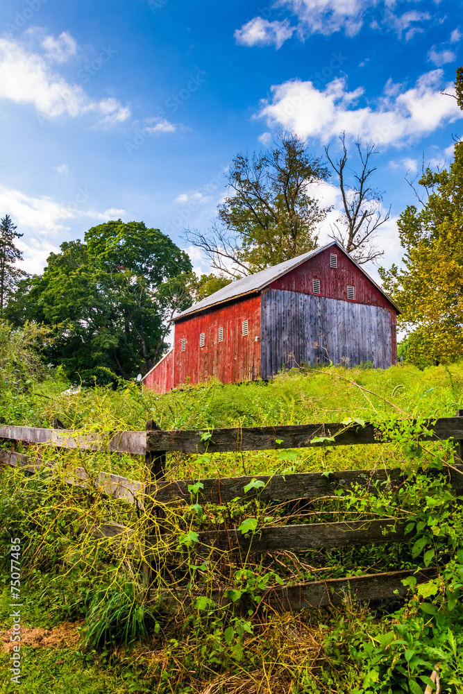 Obraz premium Fence and barn on a farm in rural York County, Pennsylvania.