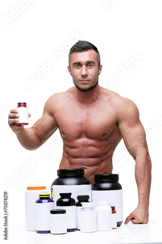 Portrait of a serious muscular man with sports nutrtion photo