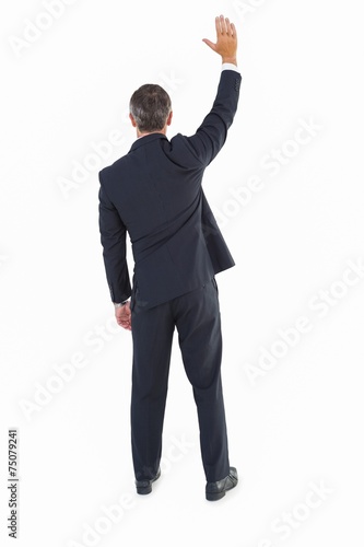 Rear view of a businessman in suit waving