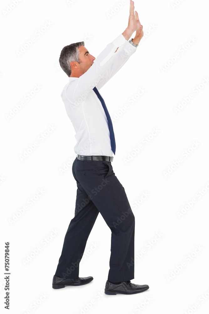 Businessman in suit looking up and pushing Businessman in suit looking up and pushing