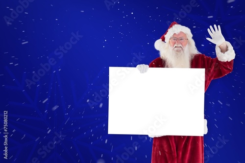 Composite image of santa holds a sign and is waving © WavebreakmediaMicro