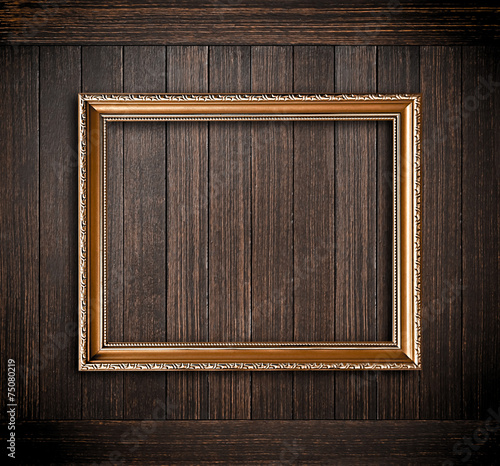 Golden picture frame on old dark wood background