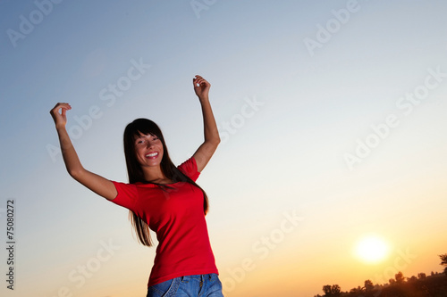 Young woman with raised arms outdoor