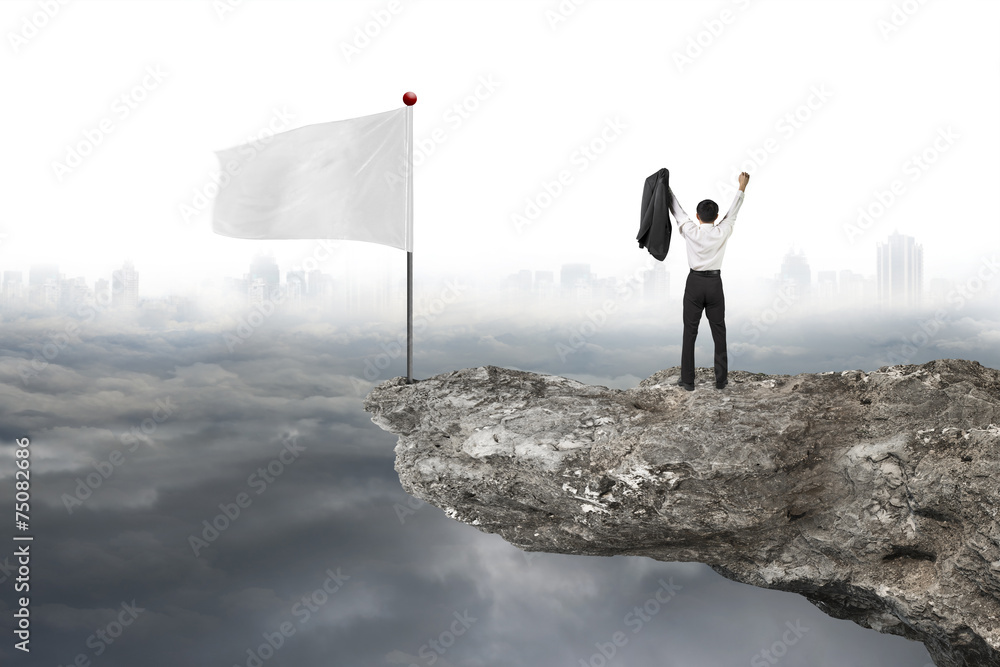 man cheering on cliff with white flag and cloudy cityscape man cheering on cliff with white flag and cloudy cityscape