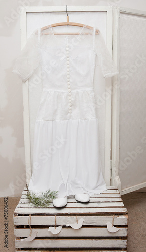 Vintage wedding dress and shoes on a wooden background