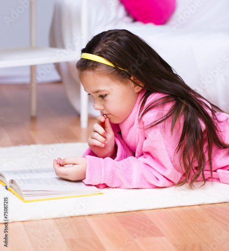 Little girl is reading a book