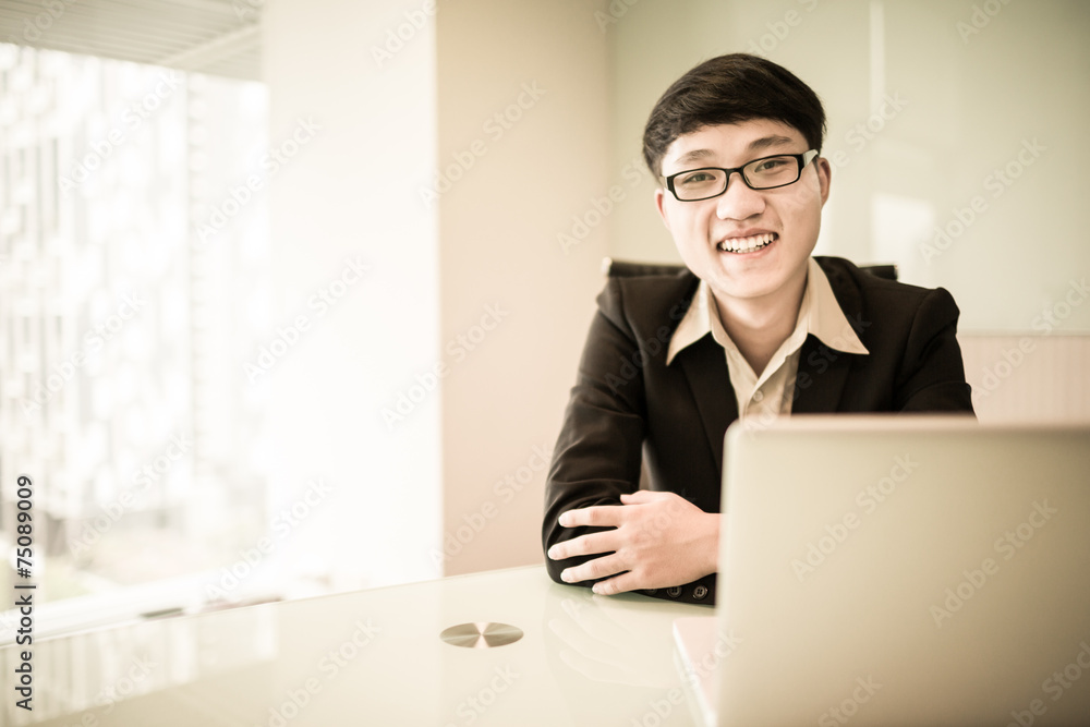 Young handsome man using laptop in his office Young handsome man using laptop in his office