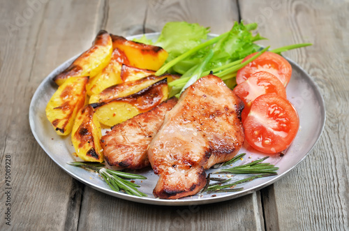 Grilled pork chop on rustic table