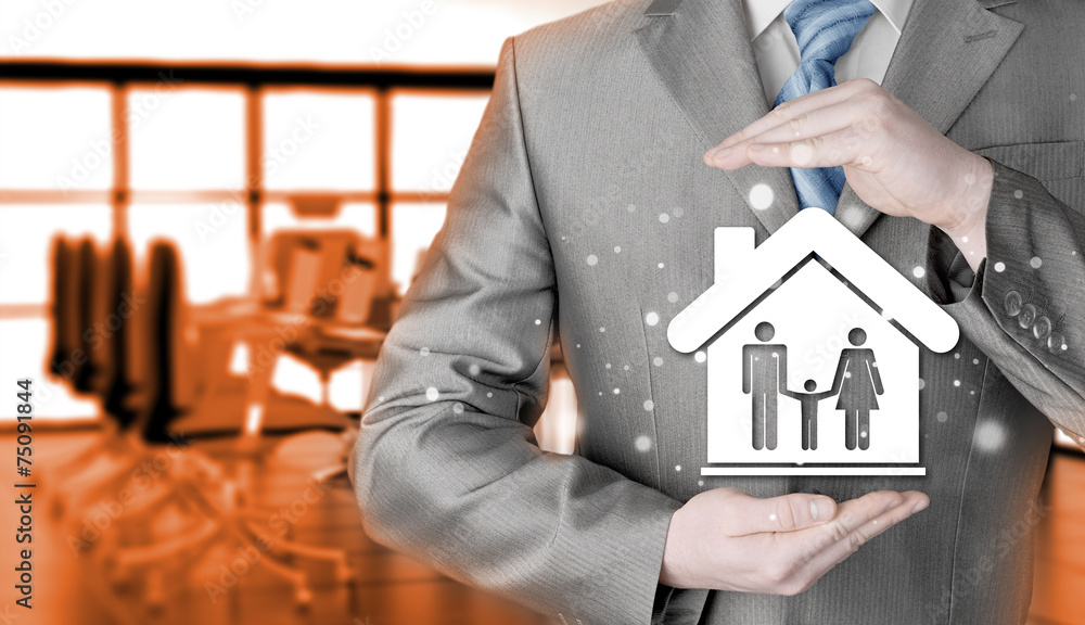 businessman protecting family in home with hands businessman protecting family in home with hands