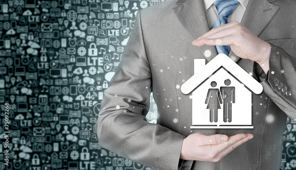 businessman protecting family in home with hands