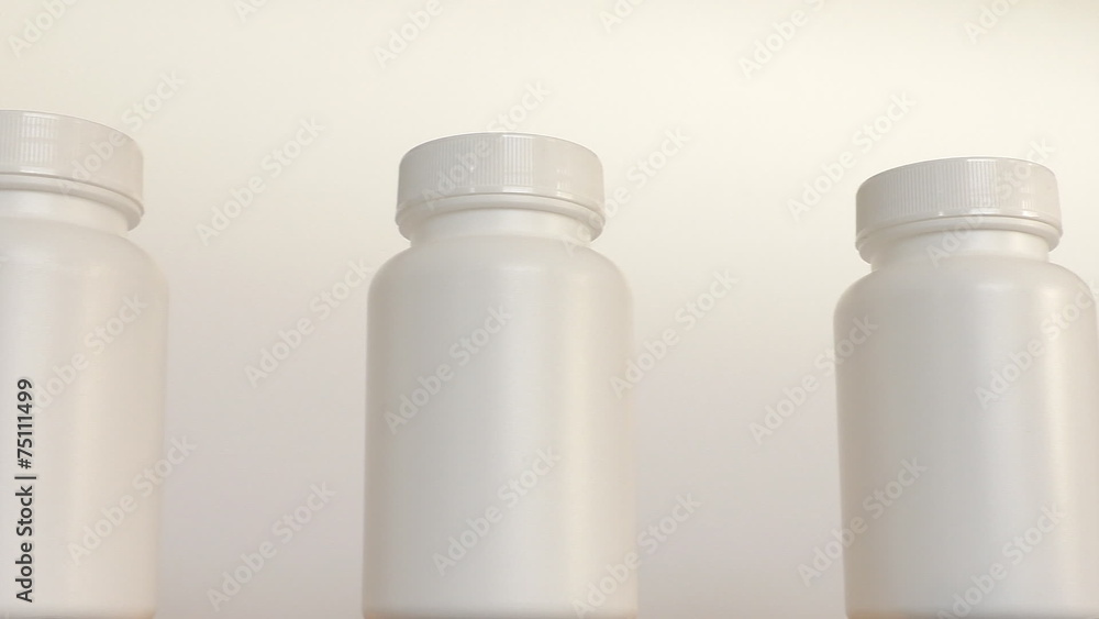 Close up of row of white bottles on conveyor belt Close up of row of white bottles on conveyor belt