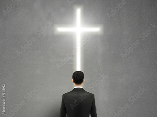 businessman stands in front of the cross light