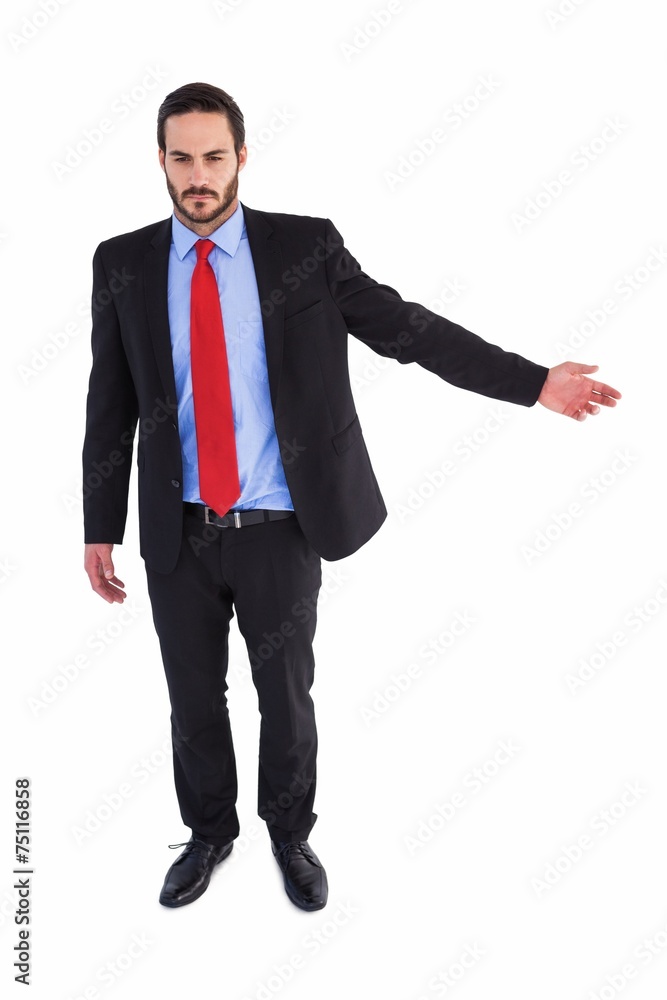 Unsmiling businessman showing something with his hand Unsmiling businessman showing something with his hand