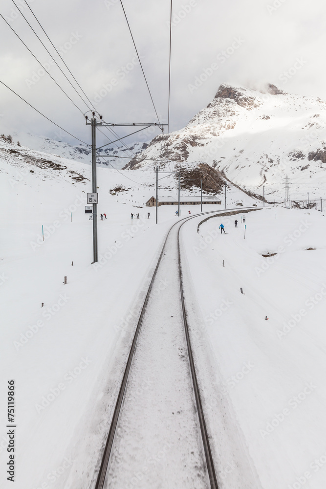 People skiing along the tracks of Bernina Express