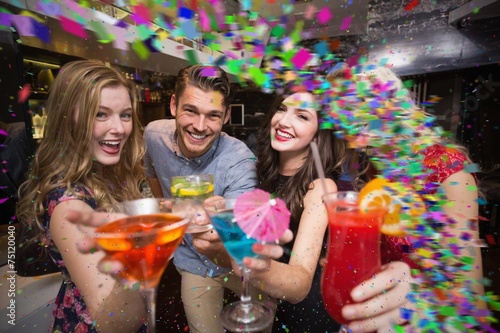 Composite image of happy friends having a drink together