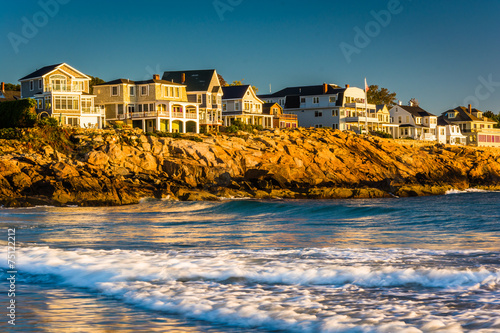 Waves in the Atlantic Ocean and houses on cliffs in York, Maine.