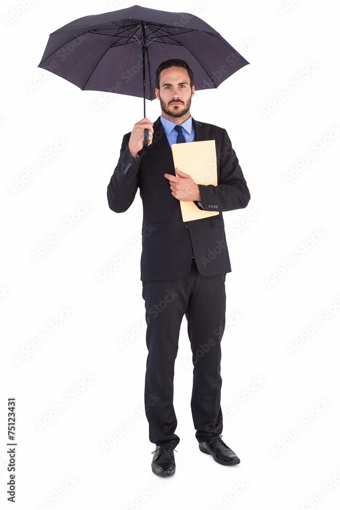 Serious businessman holding a file under umbrella Serious businessman holding a file under umbrella