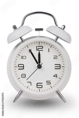 White alarm clock with hands at 5 minutes till 12