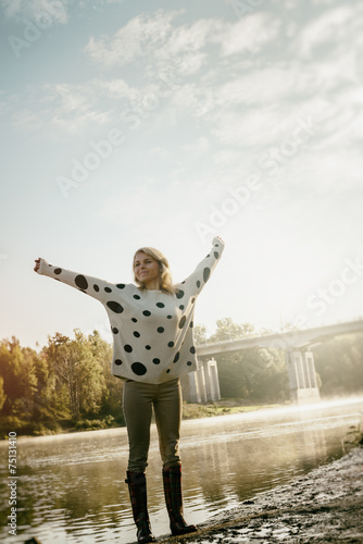 lonely happy beautiful girl walks on river bank early in morning