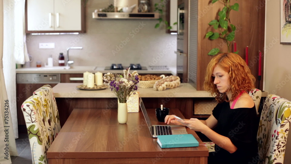 Young woman using laptop and smartphone at home office. Young woman using laptop and smartphone at home office.