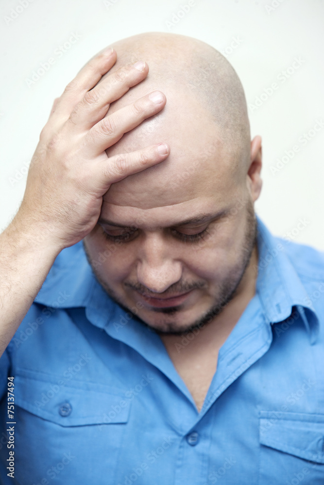 Bald man holding his head Bald man holding his head