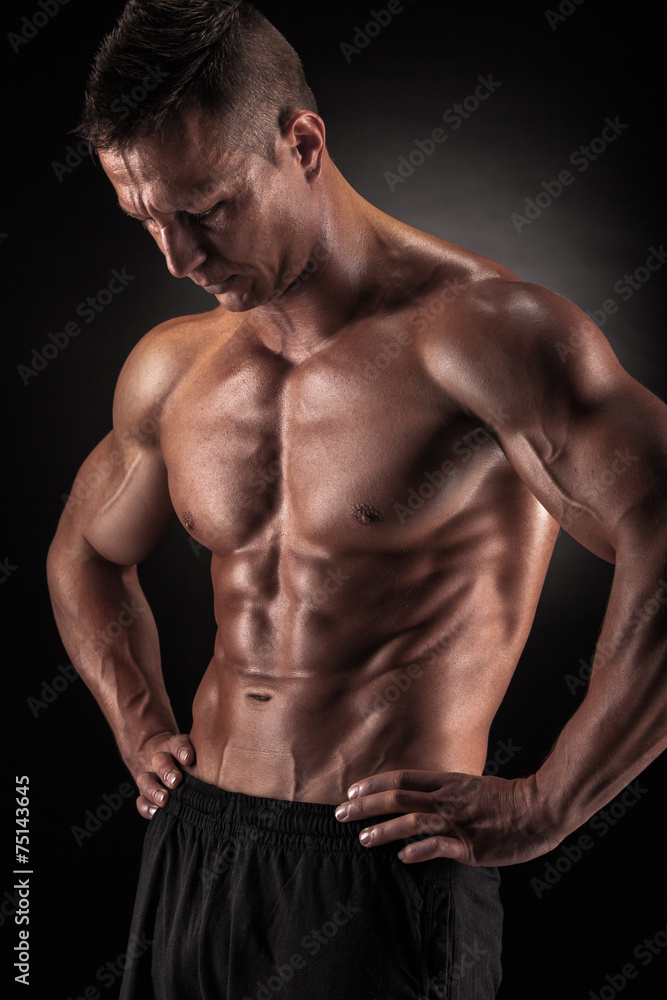 Muscular man in studio on dark background Muscular man in studio on dark background