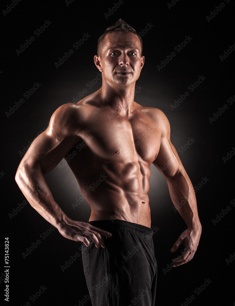 Muscular man in studio on dark background Muscular man in studio on dark background