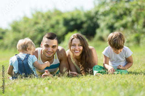 Family of four in grass at park