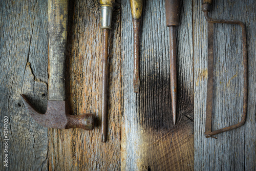 Hand Saw, Hammer and Screwdrivers on Rustic Wood Background
