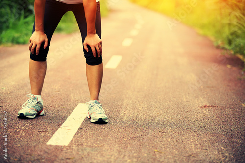 tired female runner taking a rest after running 