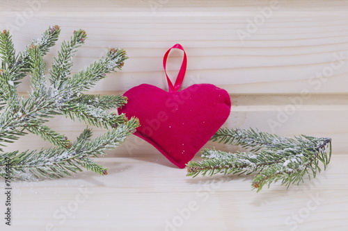 Heart and fir branches on a wooden surface