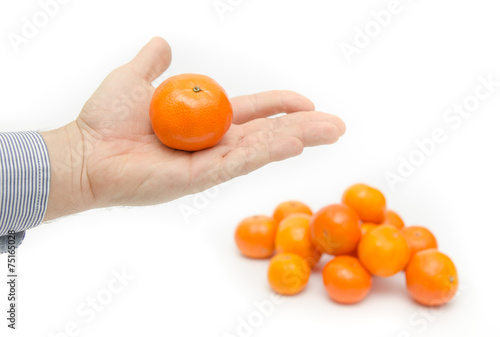 Business man hand holding an orange with a pile
