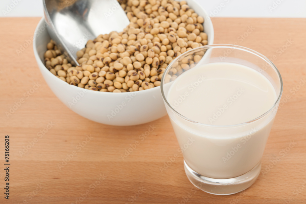 Soy milk in glass with soybeans and transfer scoop Soy milk in glass with soybeans and transfer scoop