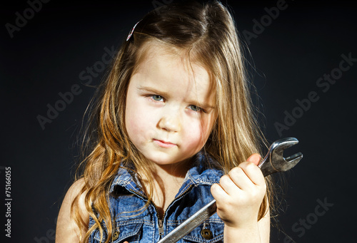 Cute little girl with gas spanner in her hands photo