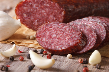 smoked sausage with spices and garlic on old table. Horizontal