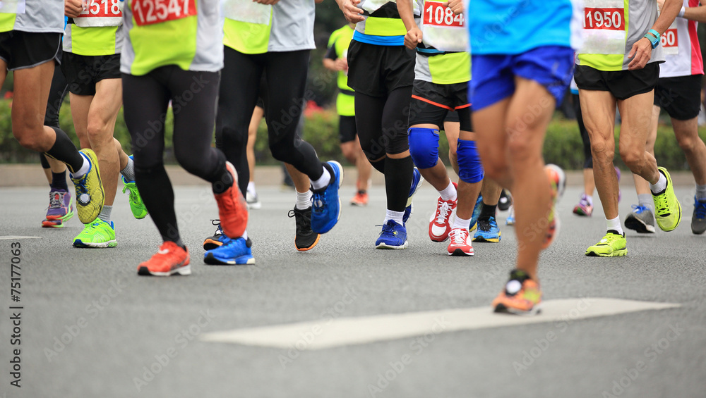 marathon athletes legs running on city road