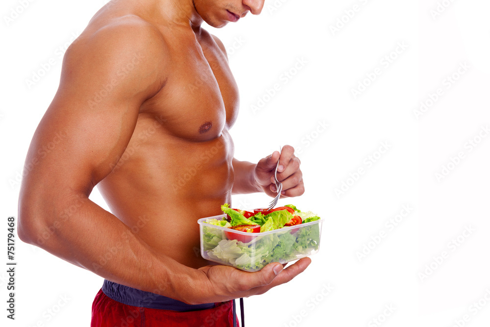 Muscular man holding a bowl of fresh salad on a white background Muscular man holding a bowl of fresh salad on a white background