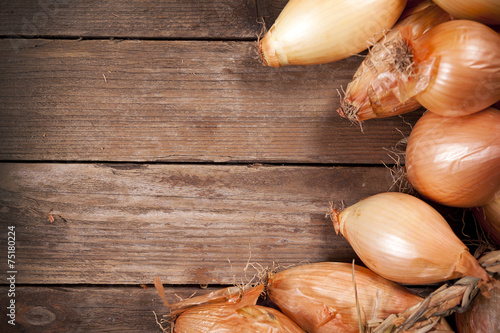 Heap of onions on wooden background