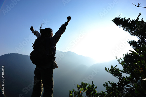 cheering woman hiker open arms at mountain peak  © lzf