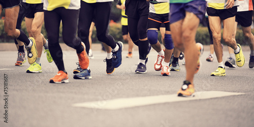 marathon athletes legs running on city road