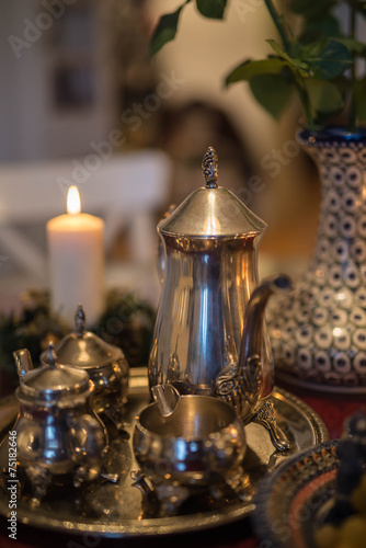 Натюрморт с серебряной посудой, чайный сет, горящая свеча, романтический ужин