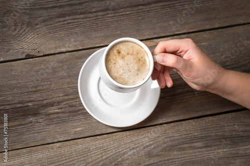 Woman holding white coffee mug. Warm mug in womans hand.