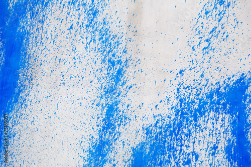 Concrete wall with blue paint splatters photo