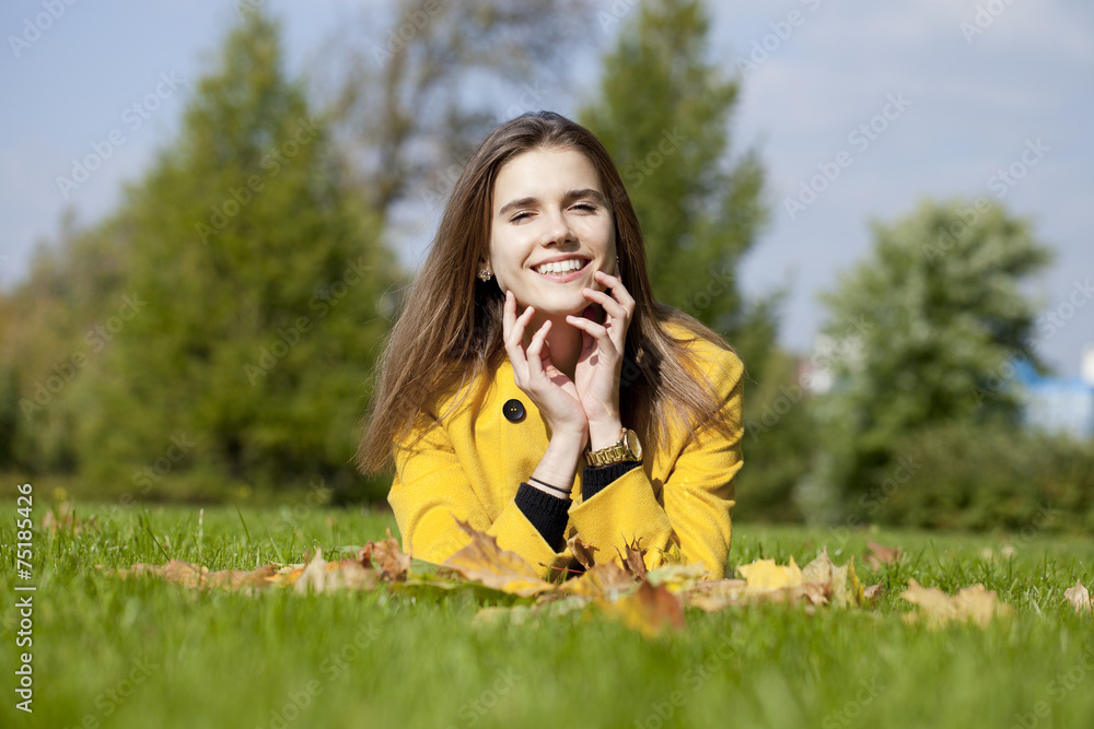 Happy young woman in yellow coat in autumn park Happy young woman in yellow coat in autumn park