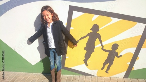 Niña dando la mano a graffiti de madre