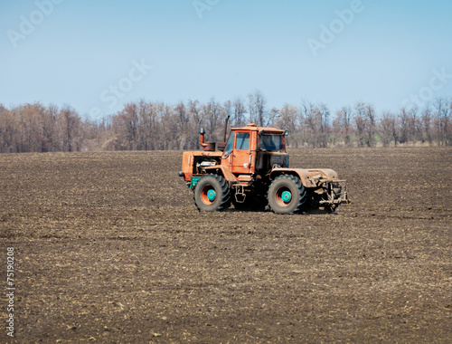 In field is moving an old tractor