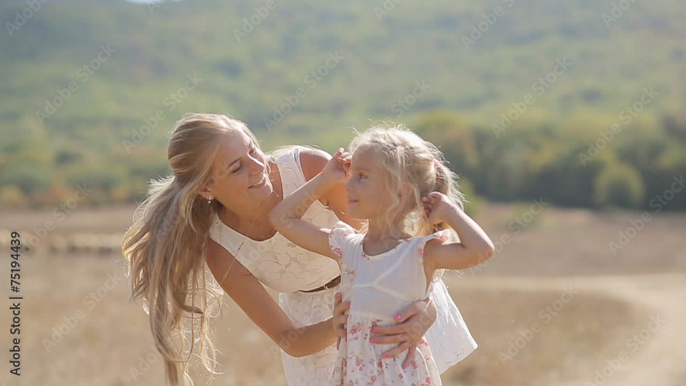 Young beautiful mother kissing little daughter and circling her Young beautiful mother kissing little daughter and circling her