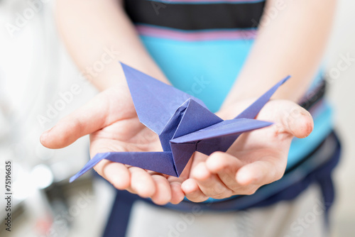 Origami crane in children's hands